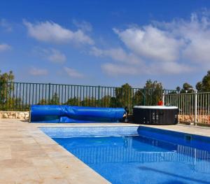 NuritGilboa Siesta / סייסטה בגלבוע的一个带蓝色水滑梯的游泳池