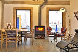 索维拉Riad EspritBleu的客厅设有壁炉、桌子和椅子