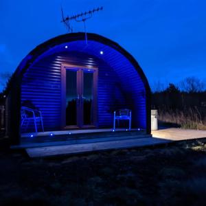 KeltyPond View Pod 3 With Private Hot Tub - Pet Friendly -Fife - Loch Leven - Lomond Hills的蓝色的灯光天文台,里面摆放着两把椅子