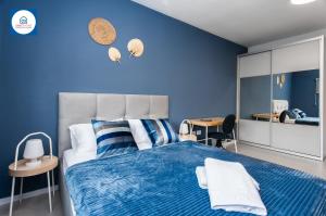 内坦亚Design apartments in Netanya的蓝色卧室设有一张带蓝色墙壁的大床