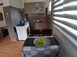 维舍格勒Apartmani Konstantin的一间小厨房,厨房内配有一张桌子,上面放着绿杯