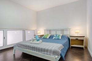 丰沙尔Funchal Boa Nova Apartment的一间卧室配有一张带蓝色床单和枕头的床。
