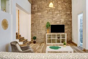 丰沙尔Funchal Boa Nova Apartment的一间带电视和砖墙的客厅