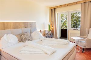 塞瓦尔兴阿特湖酒店的窗户客房内的一张白色床