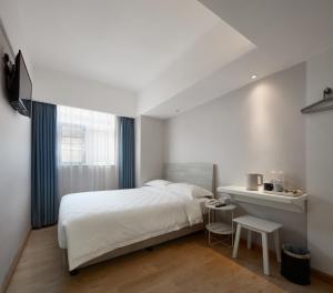 澳门澳莱大三元酒店的一间卧室配有一张床、一张桌子和一个窗户。