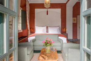 马拉喀什瑞兹兰德博宫酒店及SPA的一间卧室配有一张床、一张沙发和一张桌子