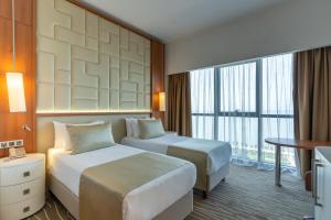 巴统Grand Bellagio Batumi Convention & Casino Hotel的酒店客房设有两张床和一张桌子。