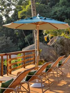 Praia do BananalPousada Três Coqueiros的露台配有椅子和遮阳伞,位于甲板上