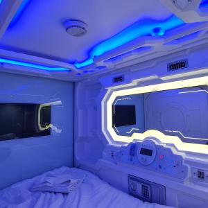 特里凡得琅TRIVPODS Capsule Hotel的客房设有床、电视和灯