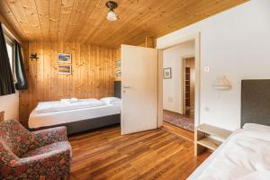 奥蒂塞伊Aquila Dolomites Residence的一间卧室,卧室内配有一张床和一把椅子