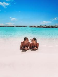 威廉斯塔德库拉索阿维拉海滨酒店的坐在海滩上的男人和女人