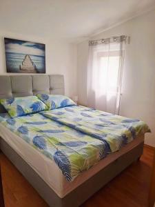 卡尼卡Andrija Apartment的卧室内的一张床铺,床上有床罩