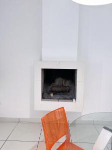 Rocchetta a VolturnoCasita1906的带壁炉的客房内的橙色椅子