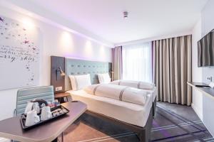 斯图加特Premier Inn Stuttgart City Centre的酒店客房配有一张床铺和一张桌子。