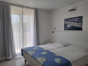 利尼亚诺萨比亚多罗假日公寓式酒店的一间卧室设有一张床和一个大窗户