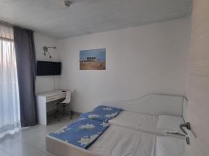 利尼亚诺萨比亚多罗假日公寓式酒店的白色卧室配有床和书桌