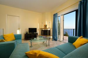 科孚镇Nisos Sunset Apartments Agios Gordios的客厅配有蓝色的沙发和玻璃桌