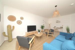 塔维拉Apartment Pepita-tavira Centre, Pool & Garage的客厅配有蓝色的沙发和电视