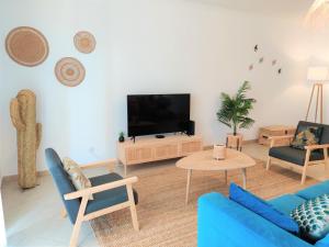 塔维拉Apartment Pepita-tavira Centre, Pool & Garage的客厅配有蓝色的沙发和电视