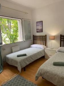 滨海比拉萨尔Casita pueblo al lado Del Mar-Vilasardemarlux4的一间卧室设有两张床和窗户。