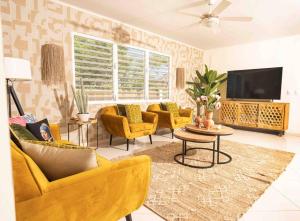 简蒂埃尔Villa Bon Bon - Jan Thiel - Vista Royal的客厅配有黄色椅子和平面电视