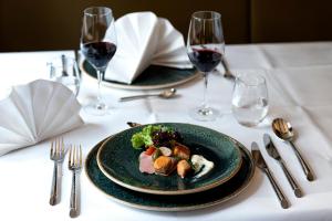 巴特德里堡祖姆布拉尼赫斯辰旅馆的一张桌子,上面放着两盘食物和酒杯