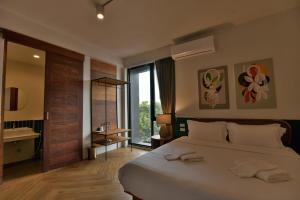 大城KWANS Ayutthaya的一间卧室设有一张大床和一个大窗户