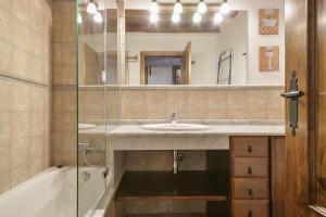 特雷多斯Luderna - Apartamento Centelha的一间带水槽、浴缸和镜子的浴室