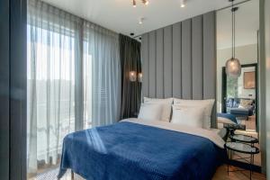 弗罗茨瓦夫EXCLUSIVE Aparthotel MARINA的一间卧室设有蓝色的床和大窗户
