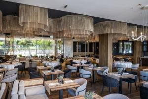 巴拉顿菲赖德Hotel Vinifera Wine & Spa 5 Stars Superior的餐厅设有桌椅和吊灯。