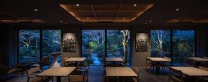 京都moksa的餐厅设有桌椅和大窗户。
