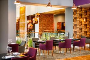 卡迪夫加的夫丽笙酒店的一间带桌子和紫色椅子的用餐室