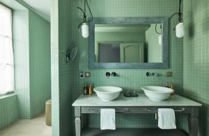 皮利尼蒙特拉谢COMO Le Montrachet的绿色浴室设有两个水槽和镜子