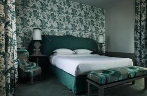 皮利尼蒙特拉谢COMO Le Montrachet的绿色卧室配有床和椅子
