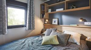 DelfstrahuizenKampari的卧室配有带枕头的床铺和窗户。