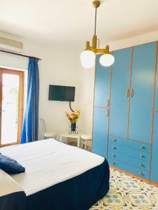 阿纳卡普里Casa Colomba的一间卧室配有一张床和一个蓝色的橱柜