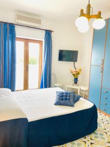 阿纳卡普里Casa Colomba的一间卧室配有一张带蓝色窗帘的大床