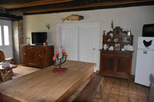 Marcillac-la-CroisilleLe hameau de Donnedevie的客厅配有木桌和冰箱。