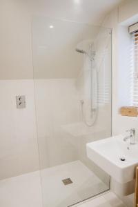 赫特福德Hertford Barn conversion的带淋浴和盥洗盆的白色浴室