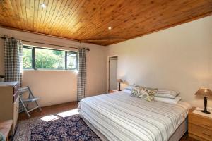 海姆维尔Ripon Country Cottage的一间卧室设有一张床和木制天花板