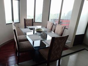 Khaira GaliNoor Villa的一间带桌椅和窗户的用餐室