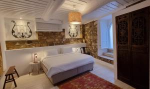 切什梅艾佩尤尔旅馆的卧室配有白色的床和石墙