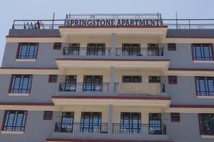 Langata RongaiSpringStone Studio Apartment Rm 19的一座建筑,上面标有读春石公寓的标志