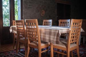 佩尔梅特Chri Chri Guesthouse的一间带桌子和6把椅子的用餐室