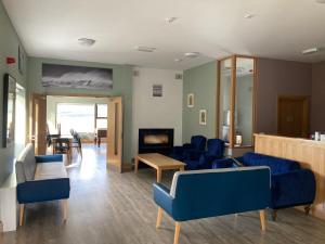 梅奥Achill Surf Centre的一间设有蓝色椅子和壁炉的等候室