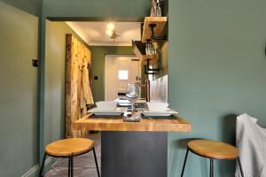 兰辛Annex by the Sea的厨房配有带凳子的柜台和带酒杯的桌子。