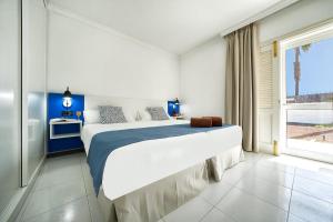 卡门港拉布兰达埃尔多拉多公寓的一间卧室设有一张大床和一个大窗户