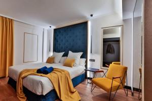 大加那利岛拉斯帕尔马斯Design Plus Bex Hotel的一间卧室配有一张大床和一张黄色椅子