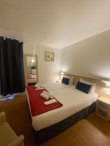达马利百合Budget Hotel Melun Sud - Dammarie Les Lys的一间卧室配有一张大床和毛巾