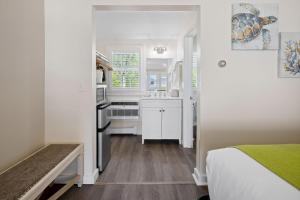 West HarwichPelham on Earle的一间小厨房,配有白色的橱柜和一张位于客房内的床